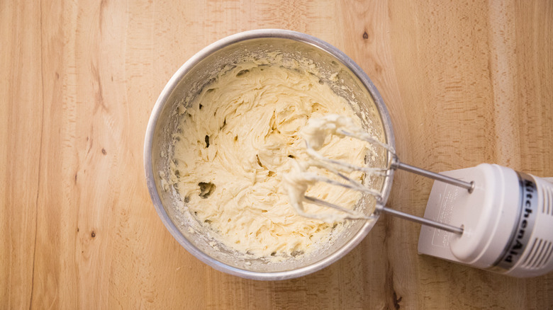 cookie batter in mixing bowl next to dirty electric mixer