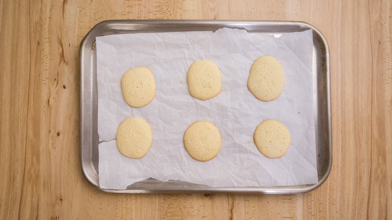 six baked cookies on lined cookie sheet