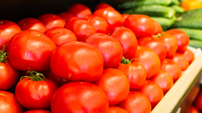 tomatoes stacked on a grocery store shelf