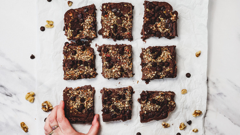Hand grabbing one of 9 brownies