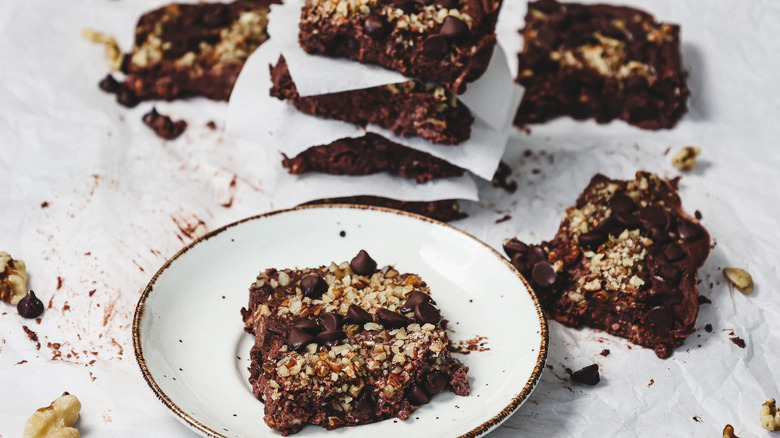 One protein brownie on a plate with stacks in background