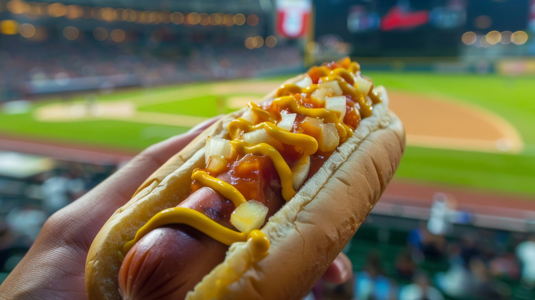 Hot dog with relish, mustard, and other condiments at a ballpark