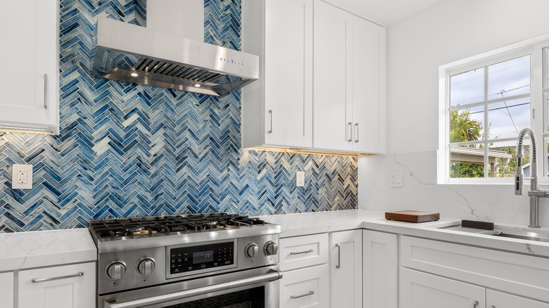 All white kitchen with blue mosaic backsplash