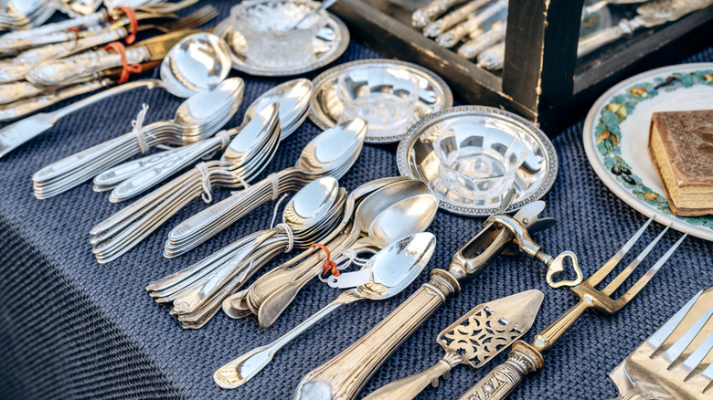 A collection of vintage and antique silverware displayed for sale