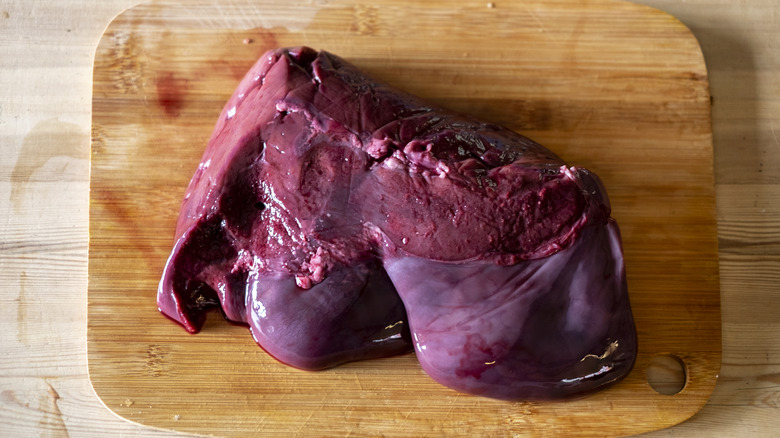 Top-down view of beef liver on a wooden cutting board