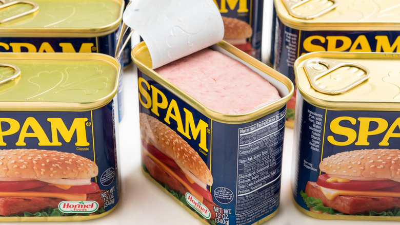 Opened can of Spam surrounded by other sealed cans