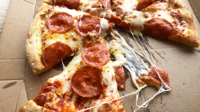 Cheesy pepperoni pizza in takeout cardboard box