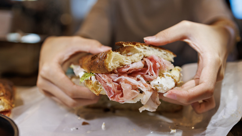 Hands holding a sandwich