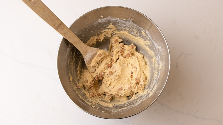 aerial view of raw caramel cookie dough in a mixing bowl with a spatula