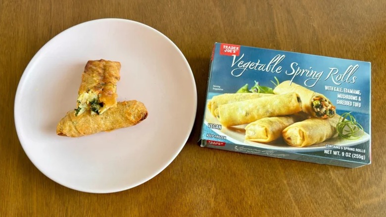 two spring rolls on a plate next to the box of Trader Joe's spring rolls
