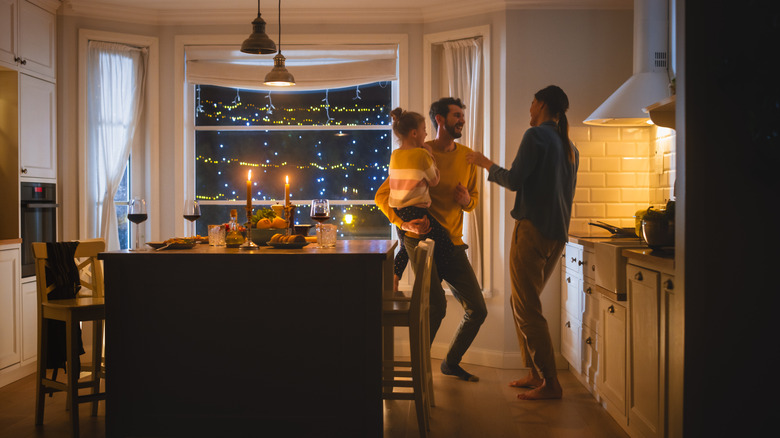 A family standing in a cozy kitchen preparing for dinner