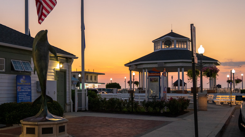sunrise at a gazebo in Rehoboth Beach, Delaware, with a dolphin statue in the foreground