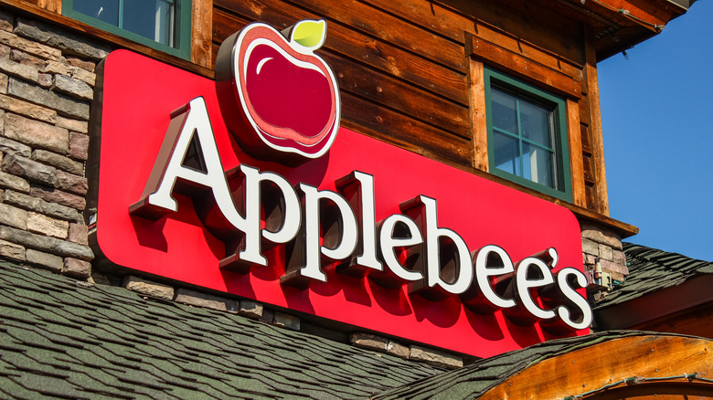 Applebee's sign in a wall shining bright red on a sunny day.