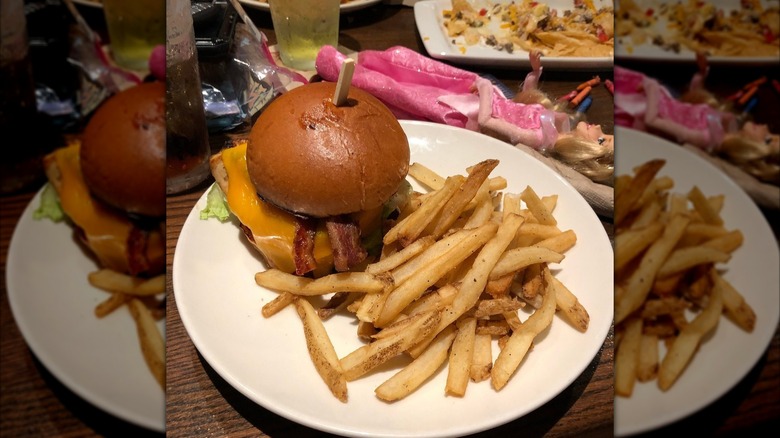 Cheeseburger with bacon and fries sitting on a small plate in Applebee's.