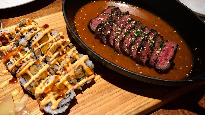 Sushi and steak on cutting board