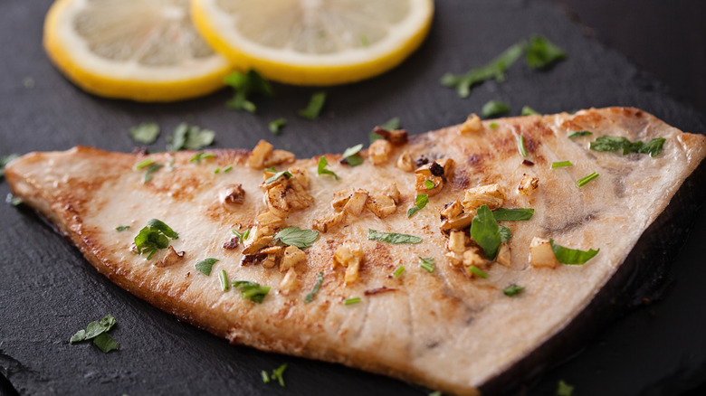 Swordfish topped with garlic and herbs with lemons