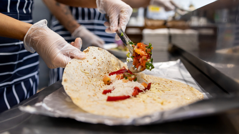 Close-up of a Mexican burrito being prepared at a restaurant