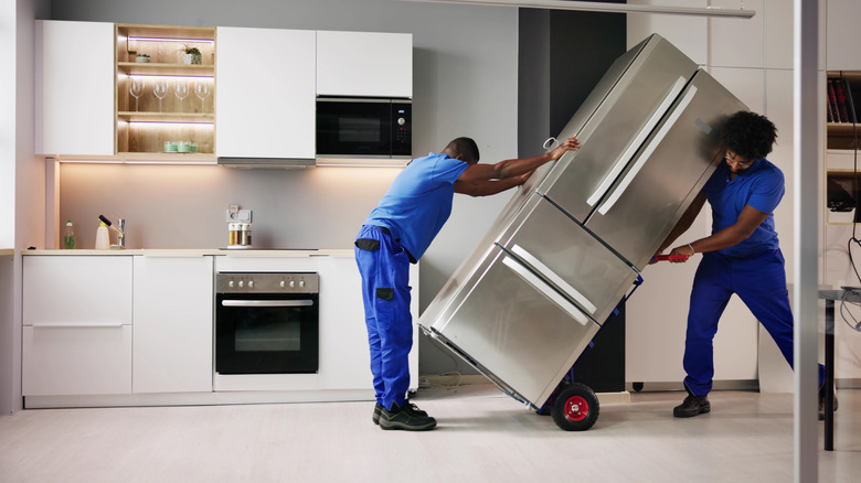 Workers moving a fridge