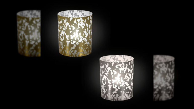 Metallic votive candles against black background