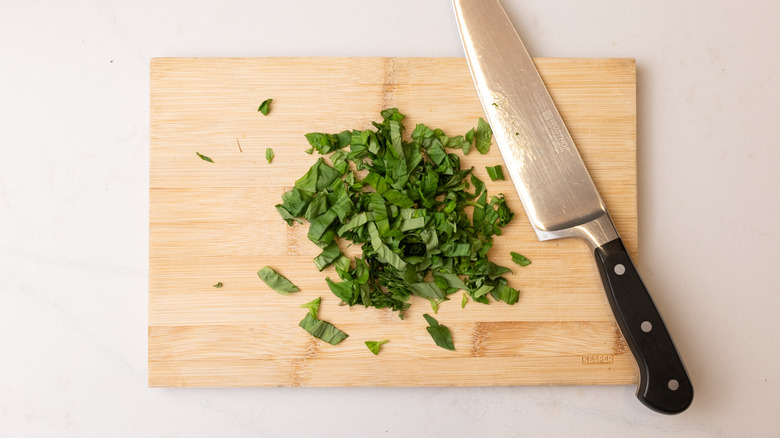 chopped basil on wooden board