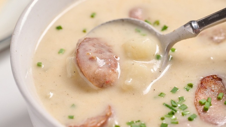 Spoonful of sausage potato soup in bowl