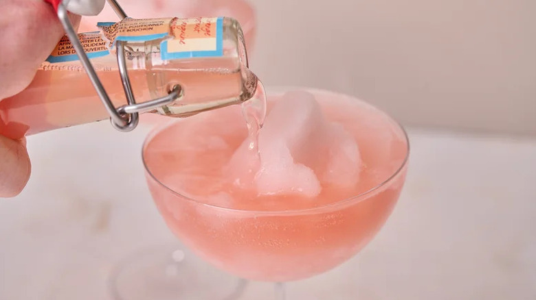 tequila being poured into a frozen paloma