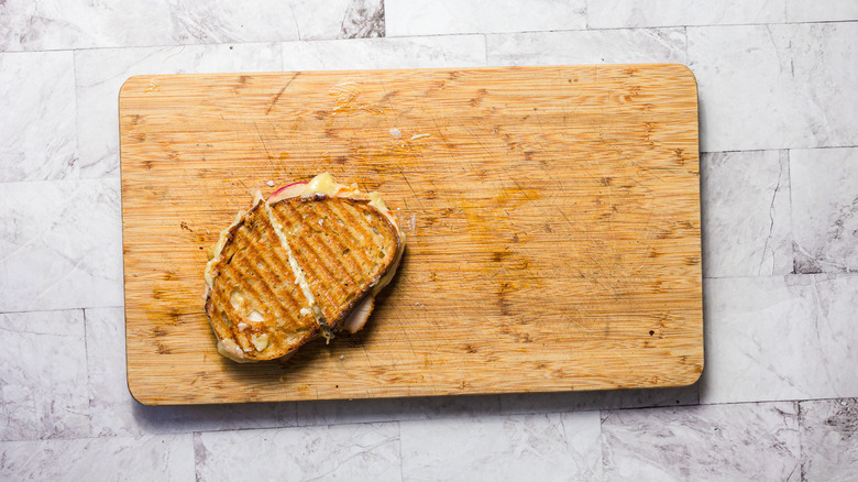 A grilled cheese cut in half on a board