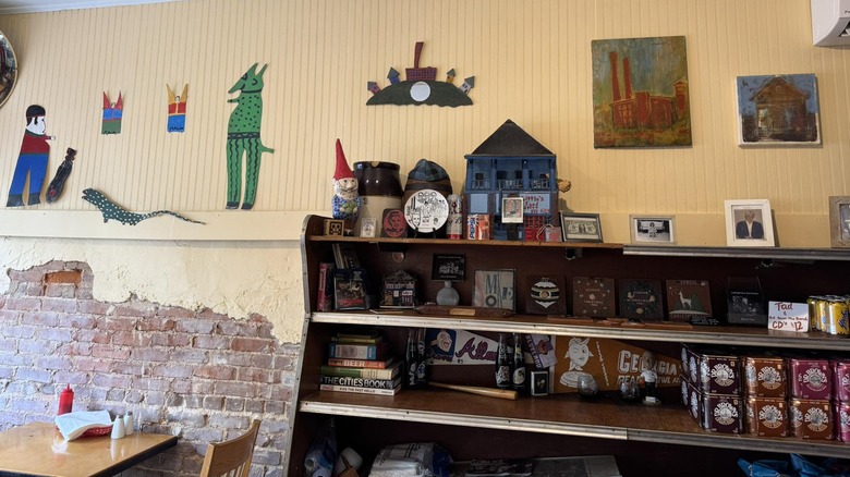 Interior of Little's Food Store with shelves stacked with random paraphernalia and art on yellow walls