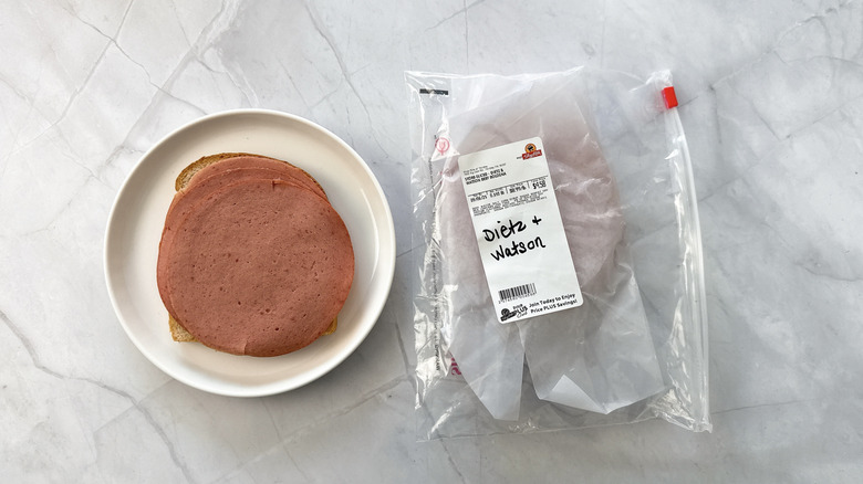 Slices of Dietz & Watson bologna on bread and plate.