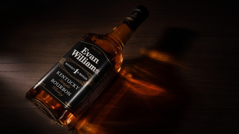 a bottle of Evan Williams bourbon laying flat on a wooden table