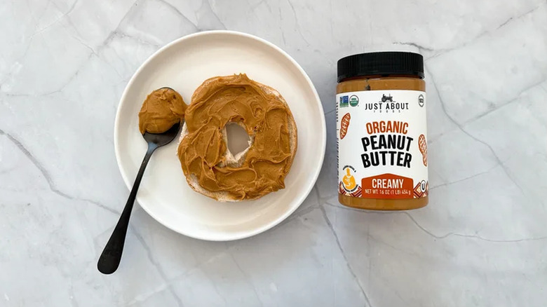 A jar of Just About Foods peanut butter with a bagel