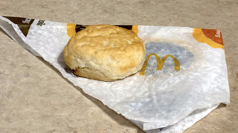 A McDonald's biscuit sitting on the wrapping paper