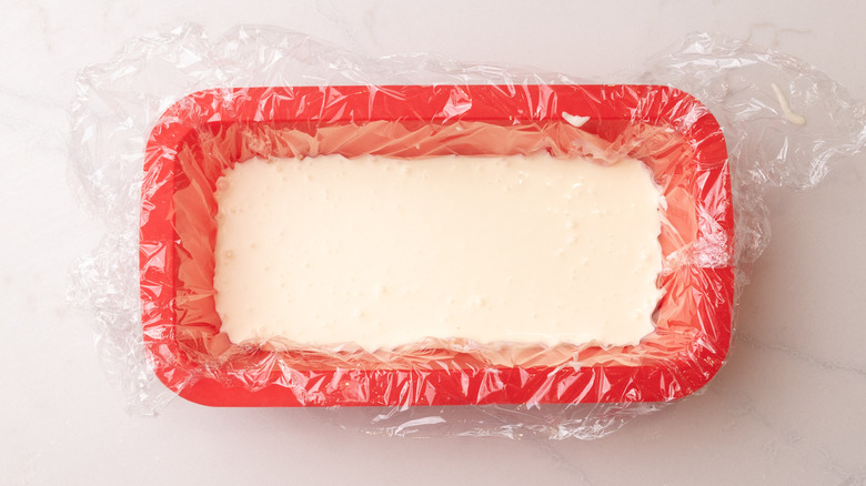 Layer of cream mixture in plastic-lined loaf pan