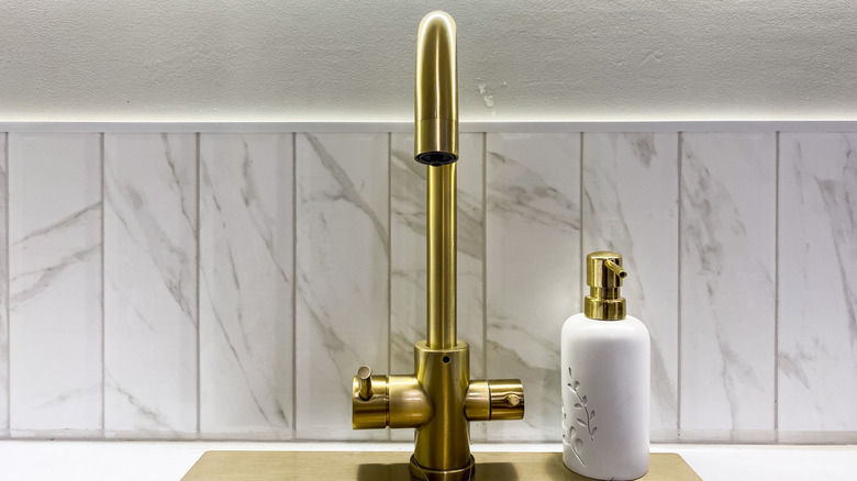 A shiny, clean gold kitchen faucet
