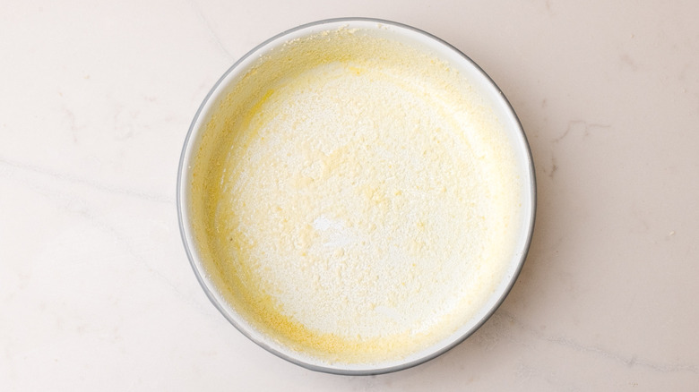Aerial view of butter and Parmesan coated baking dish on marble surface