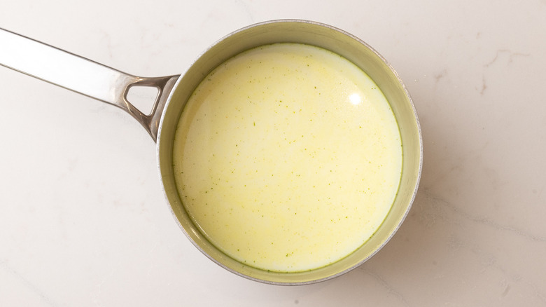 milk and chicken stock in a saucepan on marble surface