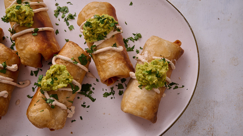 chimichangas topped with avocado and cilantro
