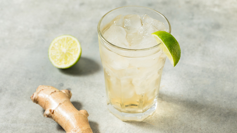 ginger ale over ice with ginger root and lime slices