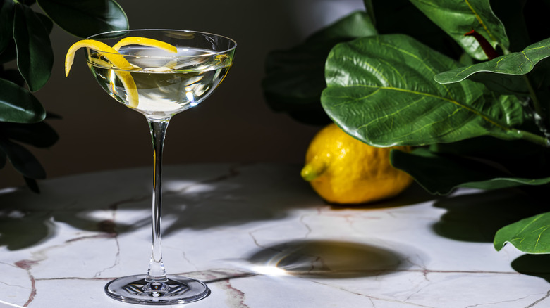 View of martini on a table in a sleek martini glass with lemon peel