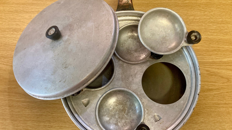 a vintage egg poaching tray on a wood table