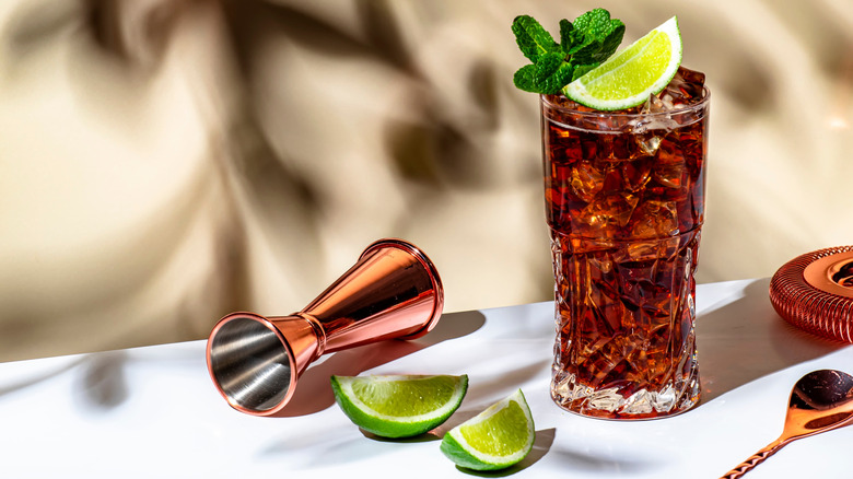 Two glasses of batanga cocktails with a lime