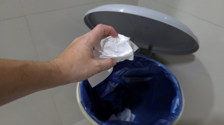 Throwing a crumpled paper towel in a garbage can