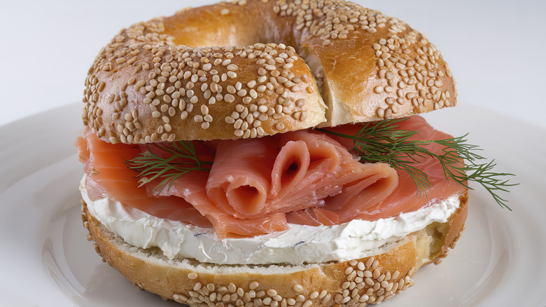 A sesame seed bagel with cream cheese and lox.