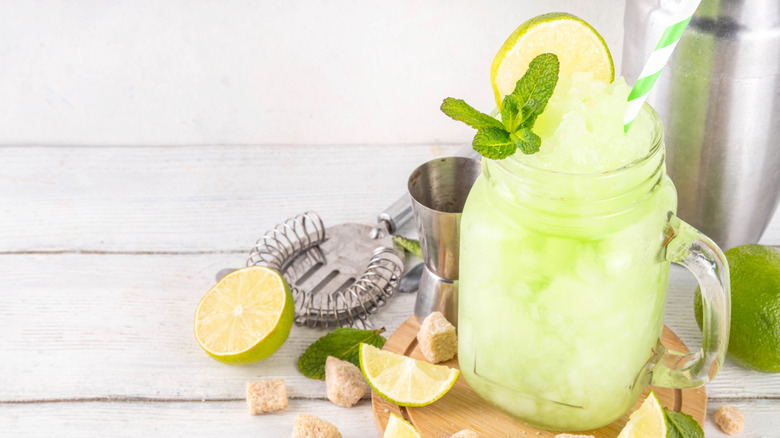 a greenish slushy drink with limes and mint in it