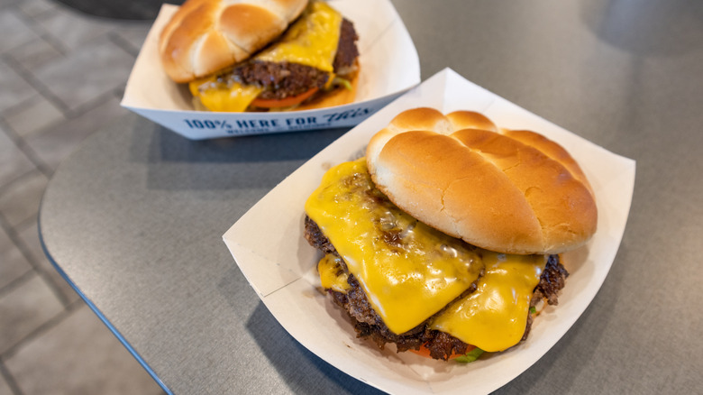 Two Culver's double patty ButterBurgers with cheese sitting in white cardboard boxes on gray table