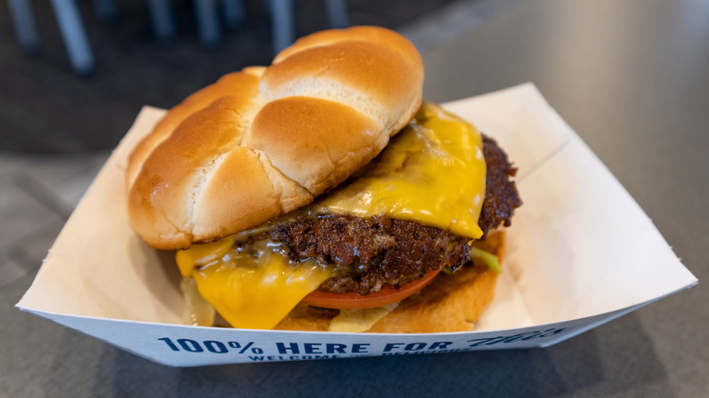 Culver's ButterBurger with cheese, lettuce, and tomato sitting inside white cardboard holder
