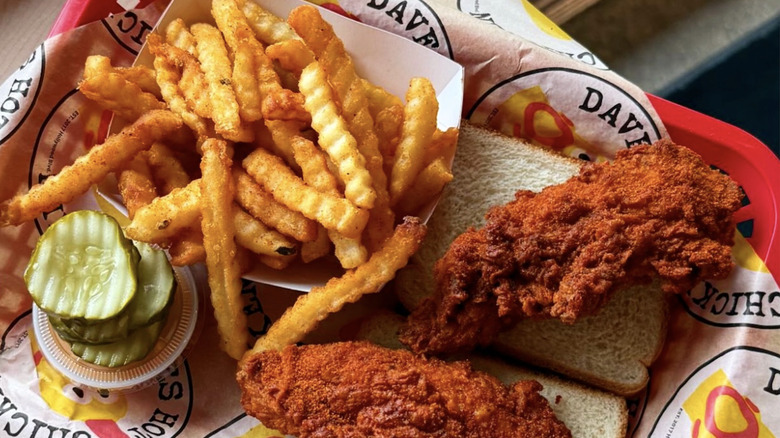 Dave's Hot Chicken with fries, pickles, and sauce container