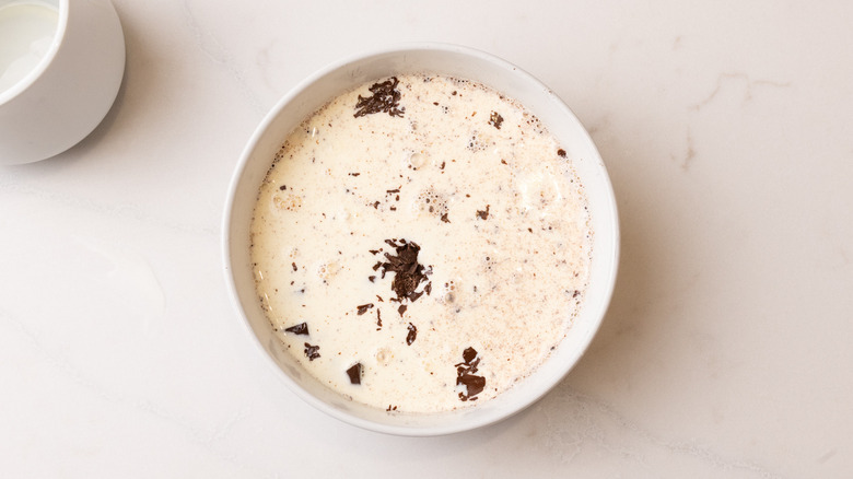 Bowl of chopped dark chocolate covered with heavy cream