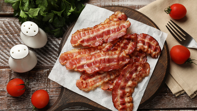 perfectly cooked  bacon on parchment with heirloom tomatoes