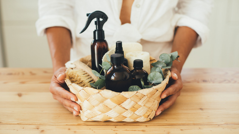 woman holding wicker basket with natural cleaning items